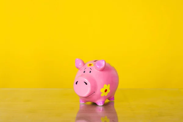 Piggy coin bank on yellow background .