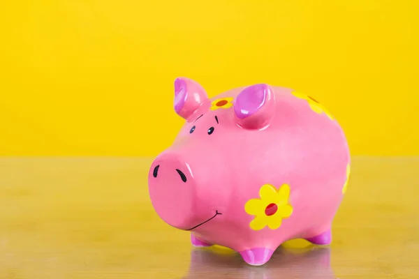 Piggy coin bank on yellow background