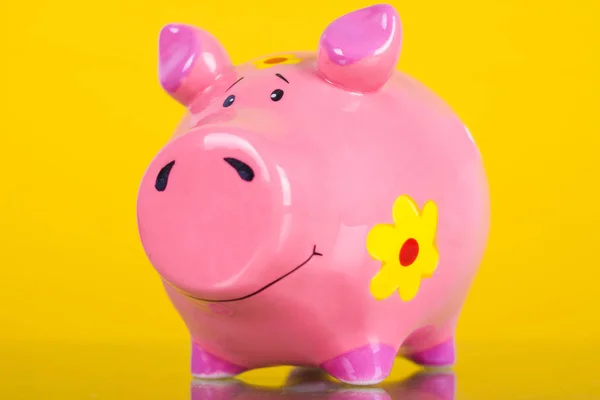 Piggy coin bank on yellow background
