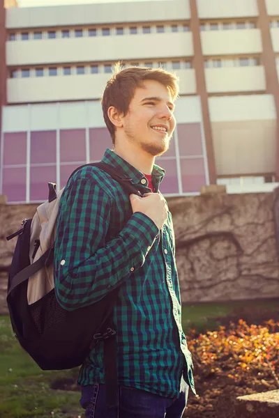 University.Smiling genç öğrenci adam Üniversitesi arka plan üzerinde bir çanta