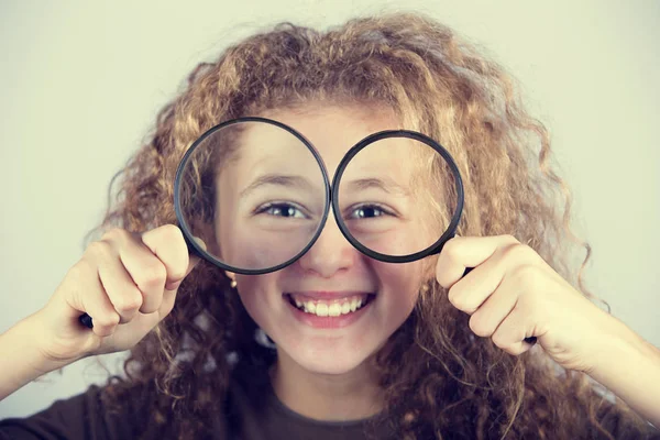 Funny portrait of cute little girl looking through  magnifying glass — Stock Photo, Image