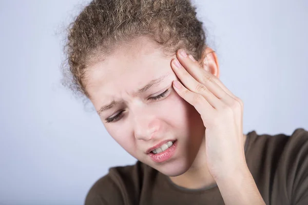 Retrato de menina sofrendo de dor de cabeça e segurando as mãos em sua cabeça.Menina estressada com problemas . — Fotografia de Stock