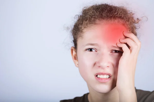 Portrait of little girl suffering from headache and holding hands on her head