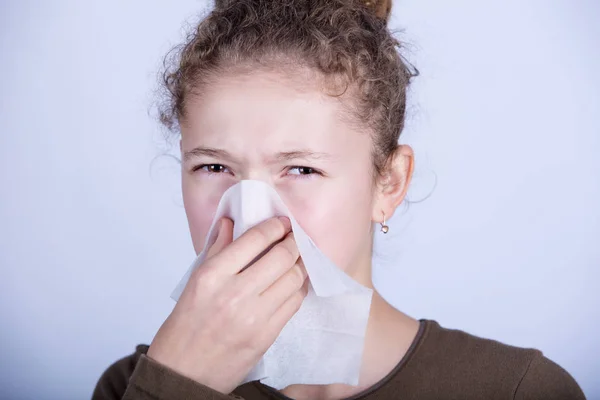 Little girl blows her nose with a napkin, isolated over white — Stock Photo, Image