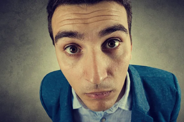 Gri arka plan üzerinde izole sürpriz genç öğrenci adam