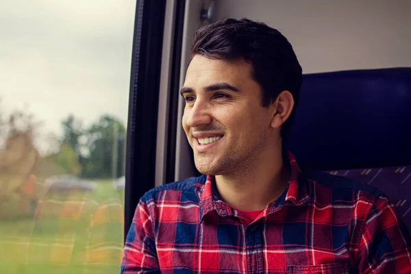 Seyahat teselli - duygu gülümseyen genç adam rahat tren ile seyahat