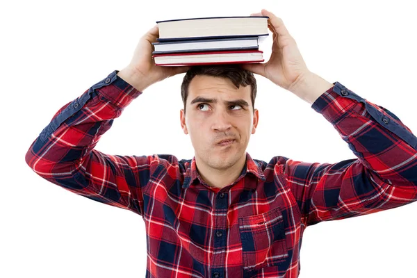 Pensando Jovem estudante segurando uma pilha de livros na cabeça — Fotografia de Stock