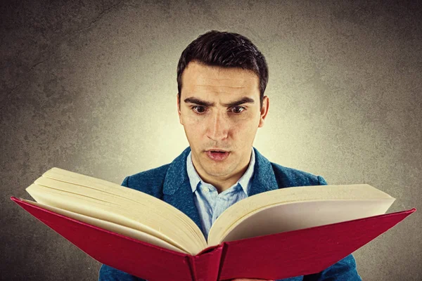 Homem surpreso segurando livro aberto. Homem estudante leitura livro, Olhos chocados loucos — Fotografia de Stock