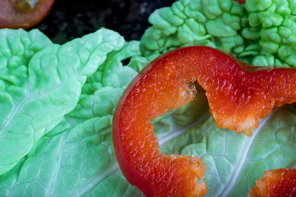 Rebanada roja de pimienta en una lechuga verde . Imágenes De Stock Sin Royalties Gratis