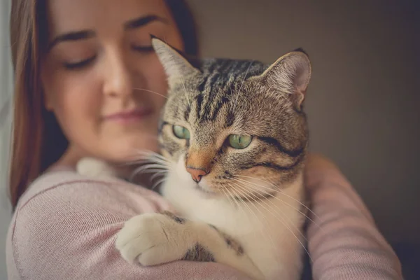 Young woman holding cat home — Stock Photo, Image