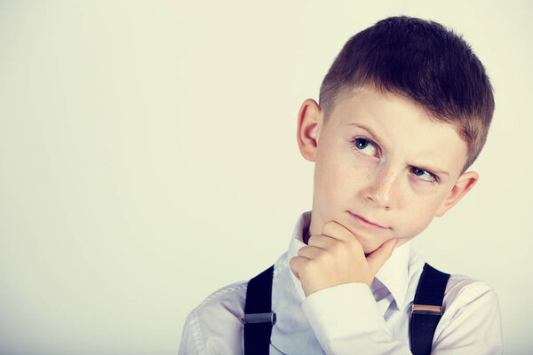 Думая о детском портрете маленького мальчика, глубоко размышляющего о чем-то с рукой на подбородке
 