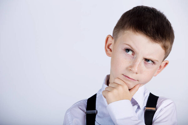 Думая о детском портрете маленького мальчика, глубоко размышляющего о чем-то с рукой на подбородке
 