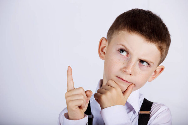 Думая о детском портрете маленького мальчика, который мыслит глубоко и указывает вверх
 