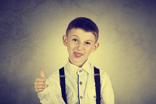 Portrett av en selvsikker liten gutt som viser tomler opp gester – stockfoto