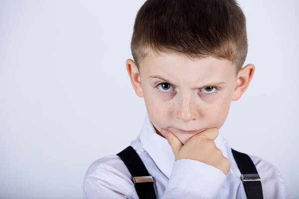 Thinking child-Portrait of a little boy thinking deeply about something with hand on chin
