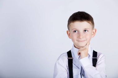 Küçük bir çocuk gülümseyen ve çene üzerinde el ile bir şey hakkında düşünme düşünme çocuk-portre 