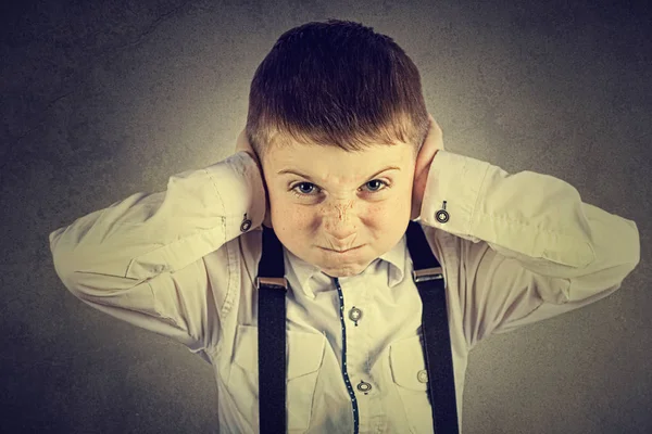 Wütender, unglücklicher, gereizter kleiner Junge, der die Ohren bedeckt — Stockfoto