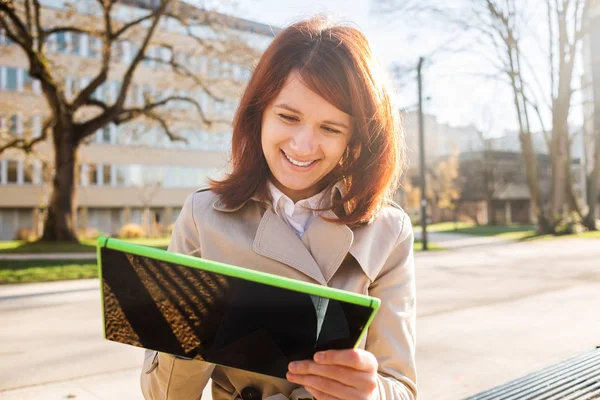 Souriant jeune étudiante tapant sur tablette à l'aide de tablette à l'université du campus . — Photo