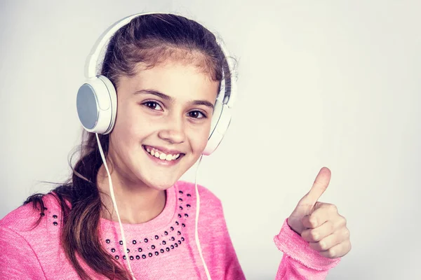 Uśmiechnięte dziewczyny z kciuk słuchanie muzyki. — Zdjęcie stockowe