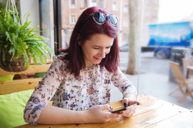 Turist kız manifatura bir restoranda akıllı telefon