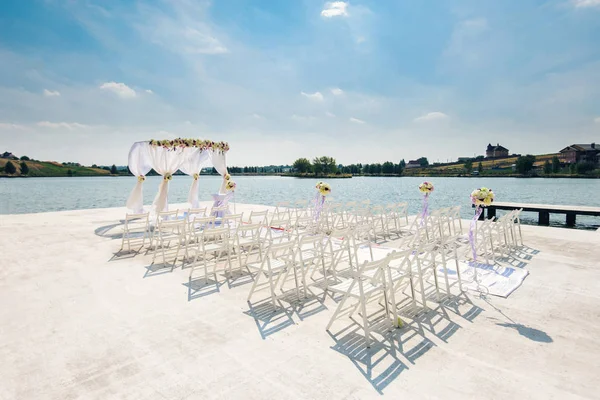 Schöner Ort in der Nähe des Sees für die Hochzeitszeremonie geschmückt — Stockfoto
