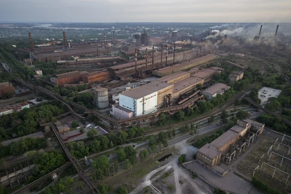 Industrial landscape in Ukraine. Steel factory with smog at sunset. Pipes with smoke. Metallurgical plant. steelworks, iron works. Heavy industry. Ecology problems, atmospheric pollutants.