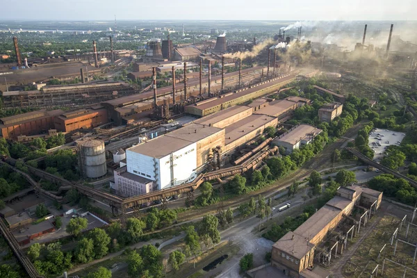 Industrial landscape in Ukraine. Steel factory with smog at sunset. Pipes with smoke. Metallurgical plant. steelworks, iron works. Heavy industry. Ecology problems, atmospheric pollutants.