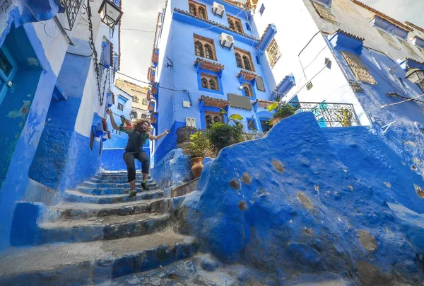 Feliz wonem saltando en las calles azules de Chefchaouen, Marruecos . — Foto de Stock