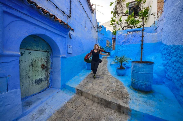 Feliz wonem caminando por las calles azules de Chefchaouen, Marruecos . — Foto de Stock