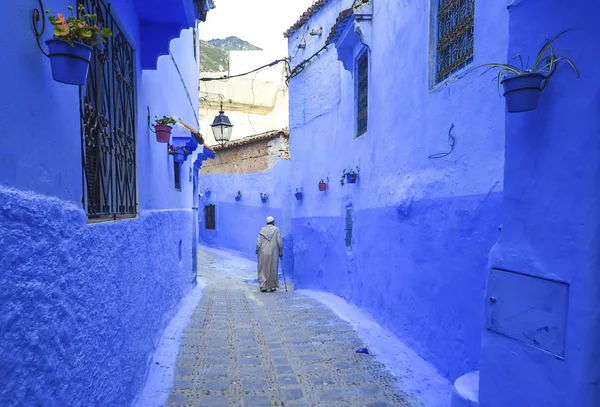 Chefchaouen şehirde bir caddede yürüyen adam tipik Fas giyim,.