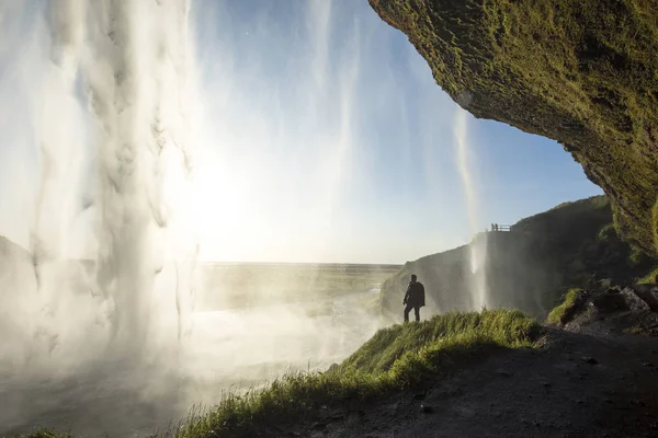 Τουρίστας που στέκεται μπροστά από το Seljalandsfoss ένα από τα πιο γνωστά καταρράκτες στη Νότια Ισλανδία, Seljalandsfoss, Ισλανδία — Φωτογραφία Αρχείου