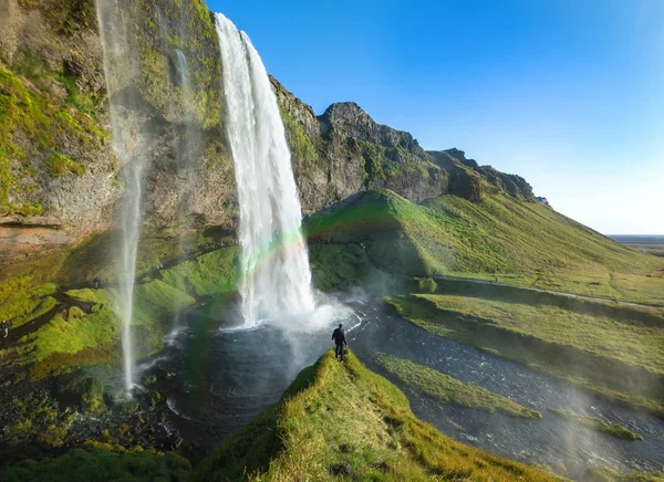 游客站在 Seljalandsfoss 在冰岛南部，Seljalandsfoss，冰岛最著名的瀑布之一 — 图库照片