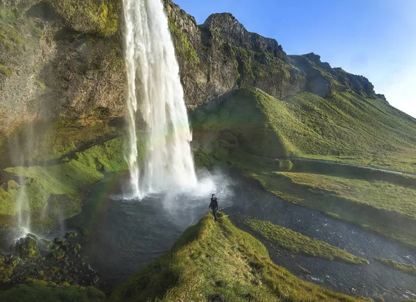 Turist står framför Seljalandsfoss ett av de mest kända vattenfallen på södra Island, Seljalandsfoss, Island — Stockfoto