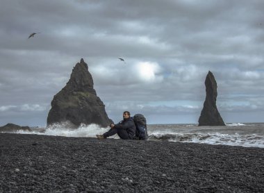 Sırt çantası seatting siyah kum plaj, Vik İzlanda ile turizm