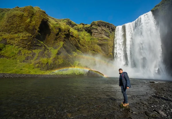 Turista stojí poblíž vodopádu Skogafoss, Island — Stock fotografie