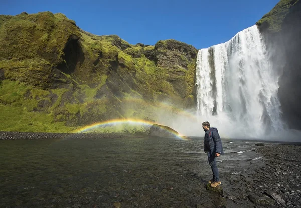 Turist står nära Skogafoss vattenfall, Island — Stockfoto