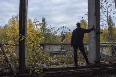 Men on the top of the roof at abandoned Pripyat city in Chernobyl Exclusion Zone at autumn time clipart