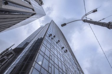 Window washers cleaning the glass facade of a skyscraper clipart