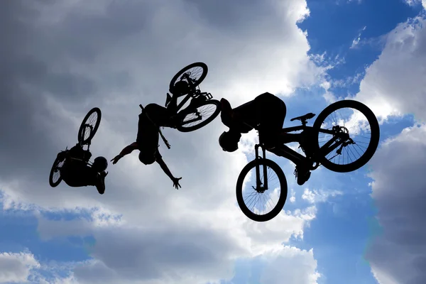 Bicicleta salto siluetas exposición múltiple — Foto de Stock