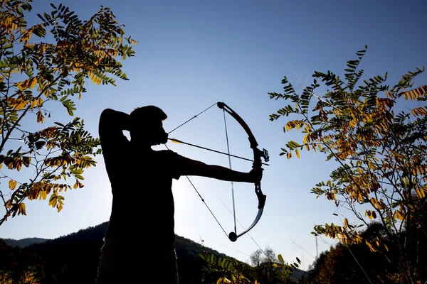 Archer drawing his compound bow silhouette — Stock Photo, Image