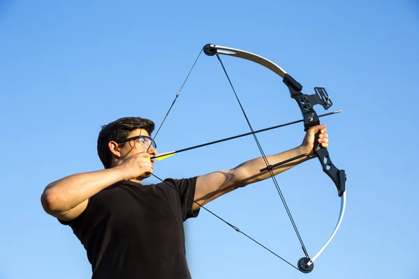 Archer drawing his compound bow blue sky — Stock Photo, Image