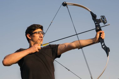 Archer draws his compound bow clipart