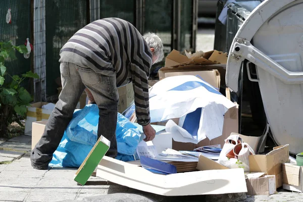 Poor homeless man collecting paper — Stock Photo, Image