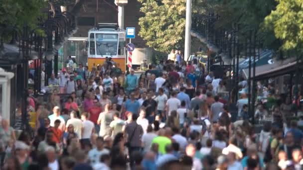 Calle llena de gente y un tranvía — Vídeos de Stock