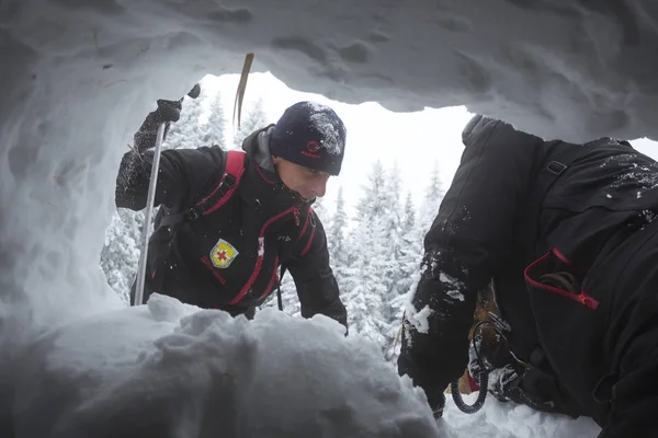 红十字会救援人员通过雪洞 — 图库照片