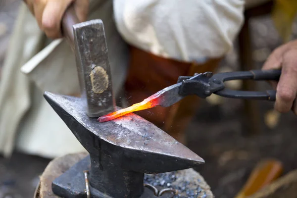 Schmied hämmert heißen Metallpfeil — Stockfoto