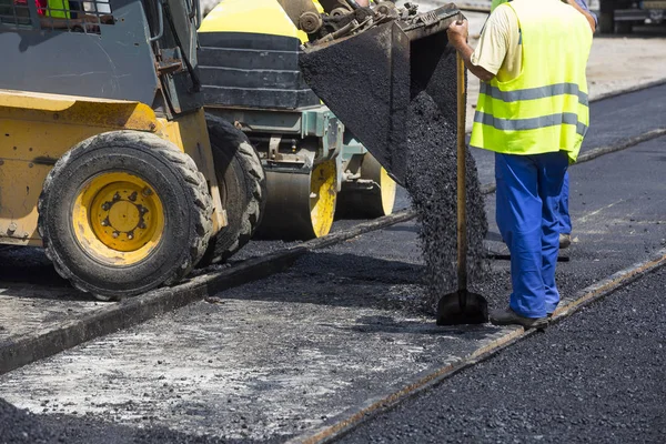 Arbeiter bauen Asphaltstraße und Bahntrassen — Stockfoto