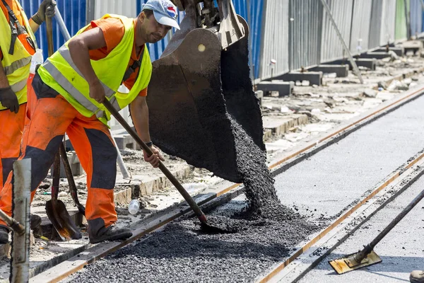 Werknemers construct asfalt weg en spoorweg lijnen — Stockfoto
