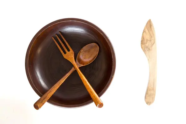 Tigela de madeira com faca, colher e garfo sobre fundo branco — Fotografia de Stock