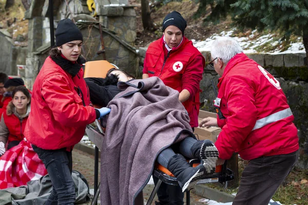 Jugendreferent des Roten Kreuzes hilft auf Trage — Stockfoto